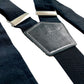 Detail close-up of handmade black linen suspenders featuring matching black leather back patch and silver hardware—crafted in Texas for groomsmen, formal events, and classic menswear.
