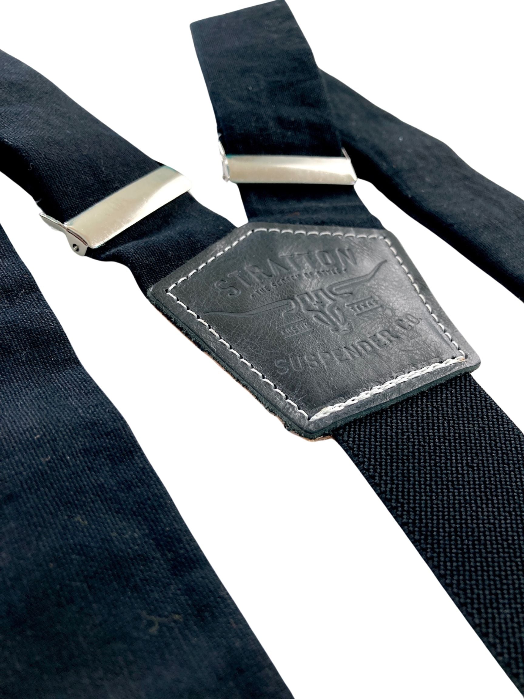 Detail close-up of handmade black linen suspenders featuring matching black leather back patch and silver hardware—crafted in Texas for groomsmen, formal events, and classic menswear.