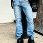 Model wearing black button-on suspenders with light wash jeans, black boots, and a white waffle knit shirt, styled for vintage-inspired everyday menswear.