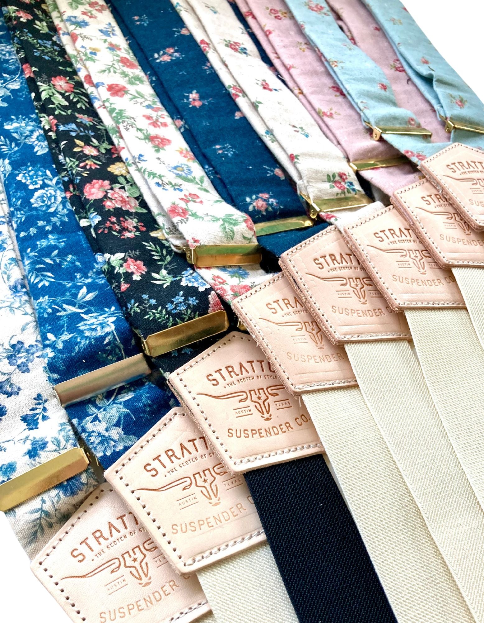 A lineup of bold floral linen suspenders by Stratton Suspender Co., showcasing a variety of prints in navy, black, ivory, and pastels—ideal for weddings, formal events, or standout groomsmen looks.