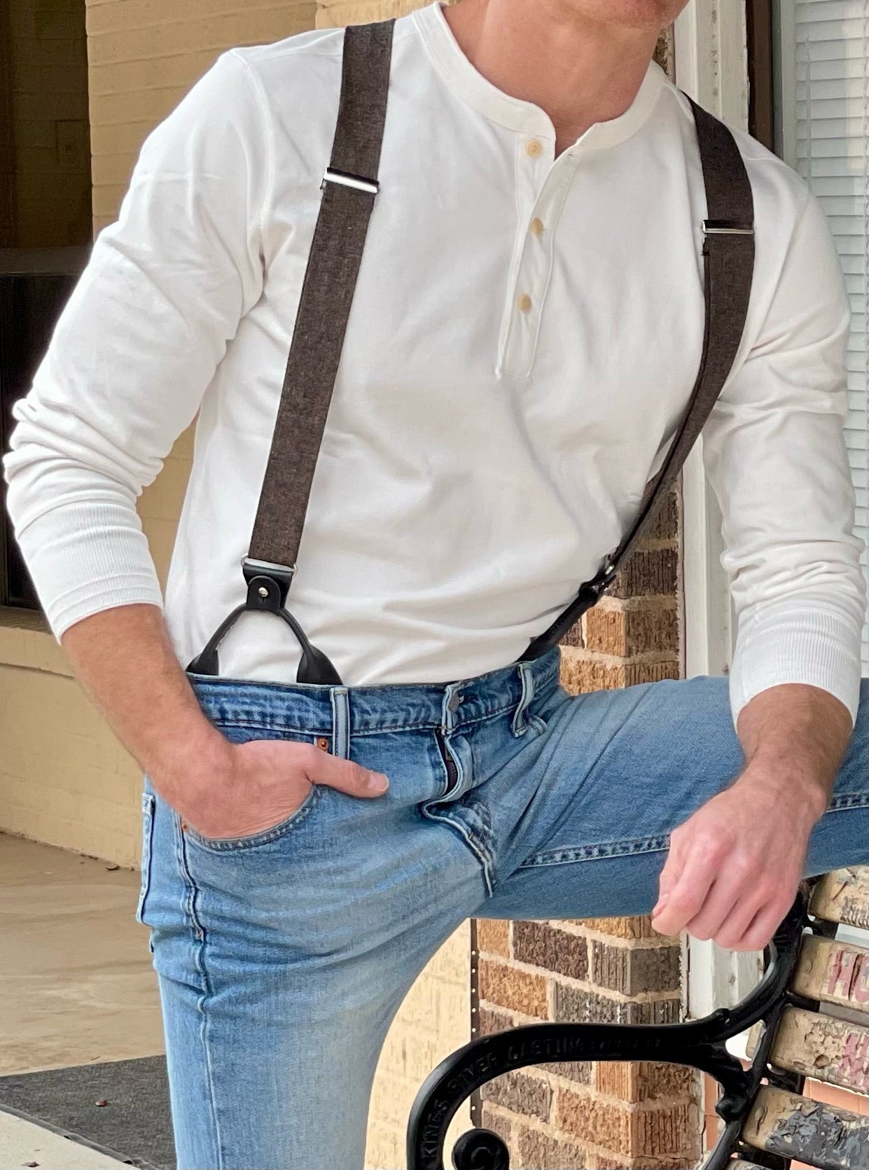 Handmade brown linen button-on suspenders with black leather loops, styled with a white Henley shirt and jeans. A vintage-inspired groomsmen accessory, perfect for weddings, rustic formalwear, and timeless menswear fashion. Stratton Suspender Co.