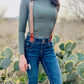 Brown women’s suspenders with magnetic leather clasps, handmade in Texas, styled for fall fashion with jeans and boots.