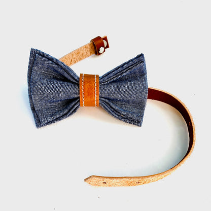 Kids' pre-tied bow tie in denim-style blue linen with a leather center wrap and adjustable leather strap.