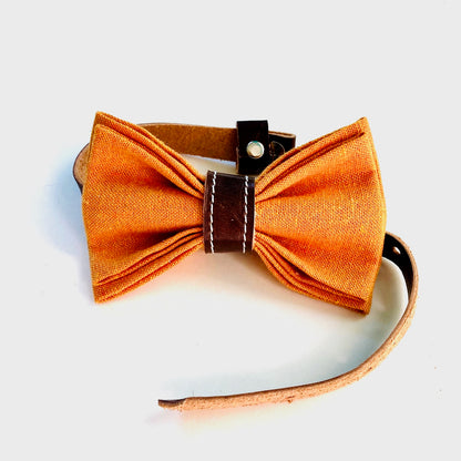 Pre-tied orange bow tie for kids, handcrafted from linen with a rich chocolate leather center and soft adjustable strap.