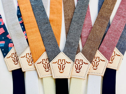 Children’s magnetic clasp suspenders in assorted linen colors with embossed leather back patches, shown in a colorful side-by-side collection.