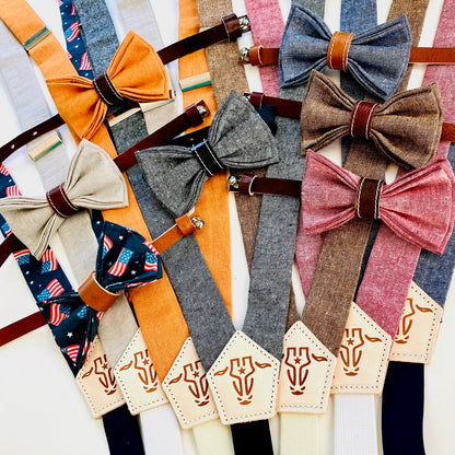 Children’s suspenders and pre-tied bow tie collection in assorted colors, handmade from linen with leather accents and magnetic clasps.