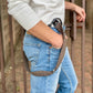 Close-up of chocolate brown linen suspenders with black full-grain leather button-on tabs, styled in a relaxed fit with vintage denim jeans and an off-white sweatshirt. Handmade in Texas by Stratton Suspender Co. for rustic workwear and everyday menswear.
