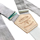 Close-up of dove gray linen suspenders featuring premium natural leather back patch and silver-tone adjusters, handmade in Texas for groomsmen and formal events.