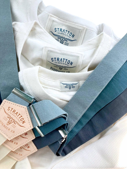 Groomsmen suspenders in popular wedding shades—dusty blue, teal, and slate—displayed over retro-inspired white shirts for vintage styling.