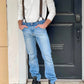 Man wearing espresso brown linen suspenders with black leather button tabs, styled with a cream henley shirt, light wash jeans, and black boots — rugged heritage menswear ideal for rustic weddings, outdoor events, or everyday vintage-inspired style.