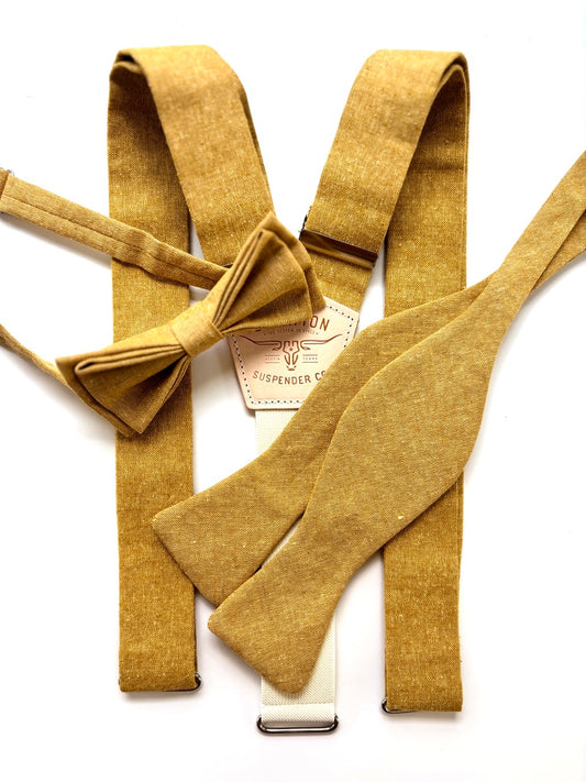 Mustard-colored suspenders and bow tie with a brand label on a white background