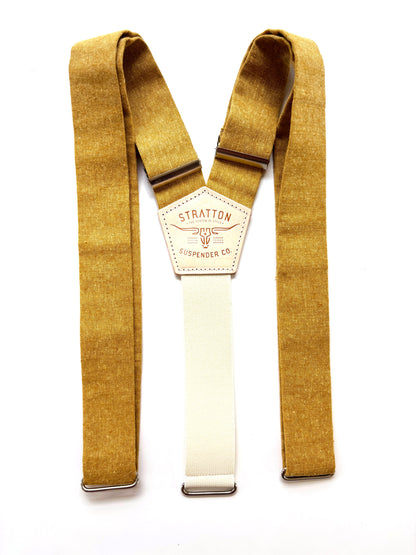Rustic marigold yellow suspenders with a cream elastic Y-back and brushed metal hardware, shown flat with Stratton leather logo patch.