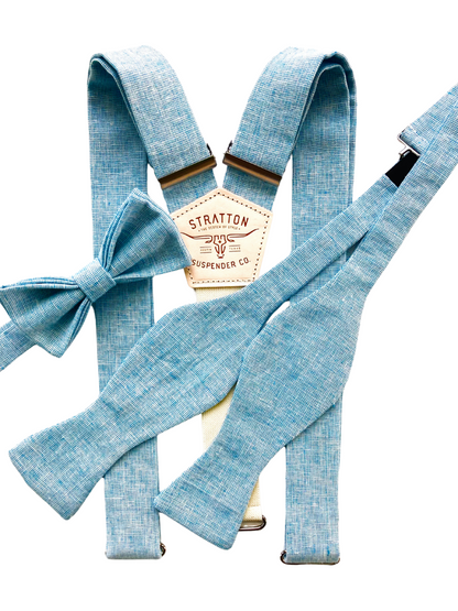Men’s matching bow tie and suspenders set in powder blue linen, featuring pre-tied and self-tie bow tie options with coordinating suspenders in a soft light blue tone.
