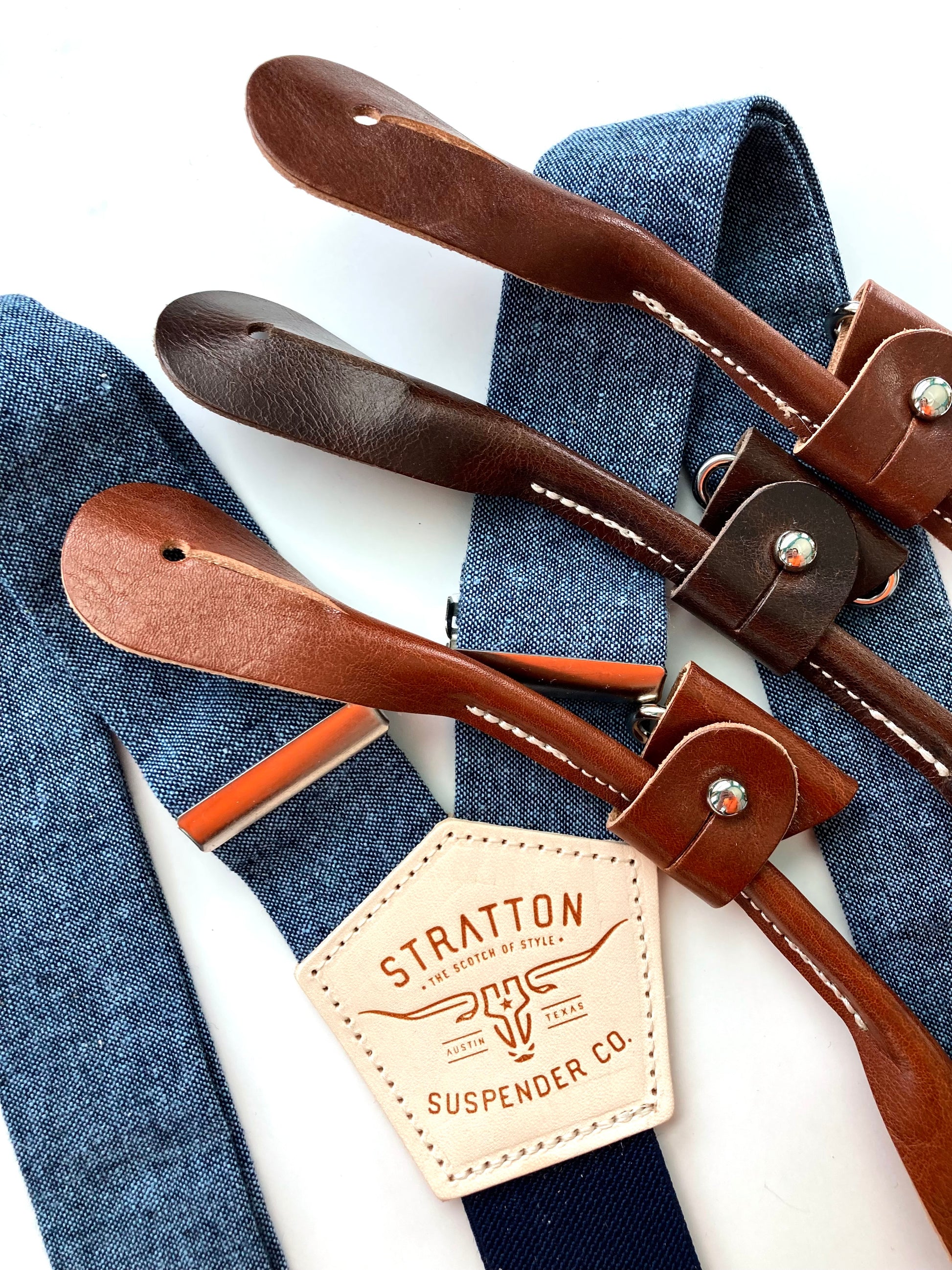 Stratton Suspender Co. nautical blue linen suspenders with tan, cognac, and chocolate full-grain leather button-on ends, ideal for groomsmen, rustic weddings, or vintage menswear.