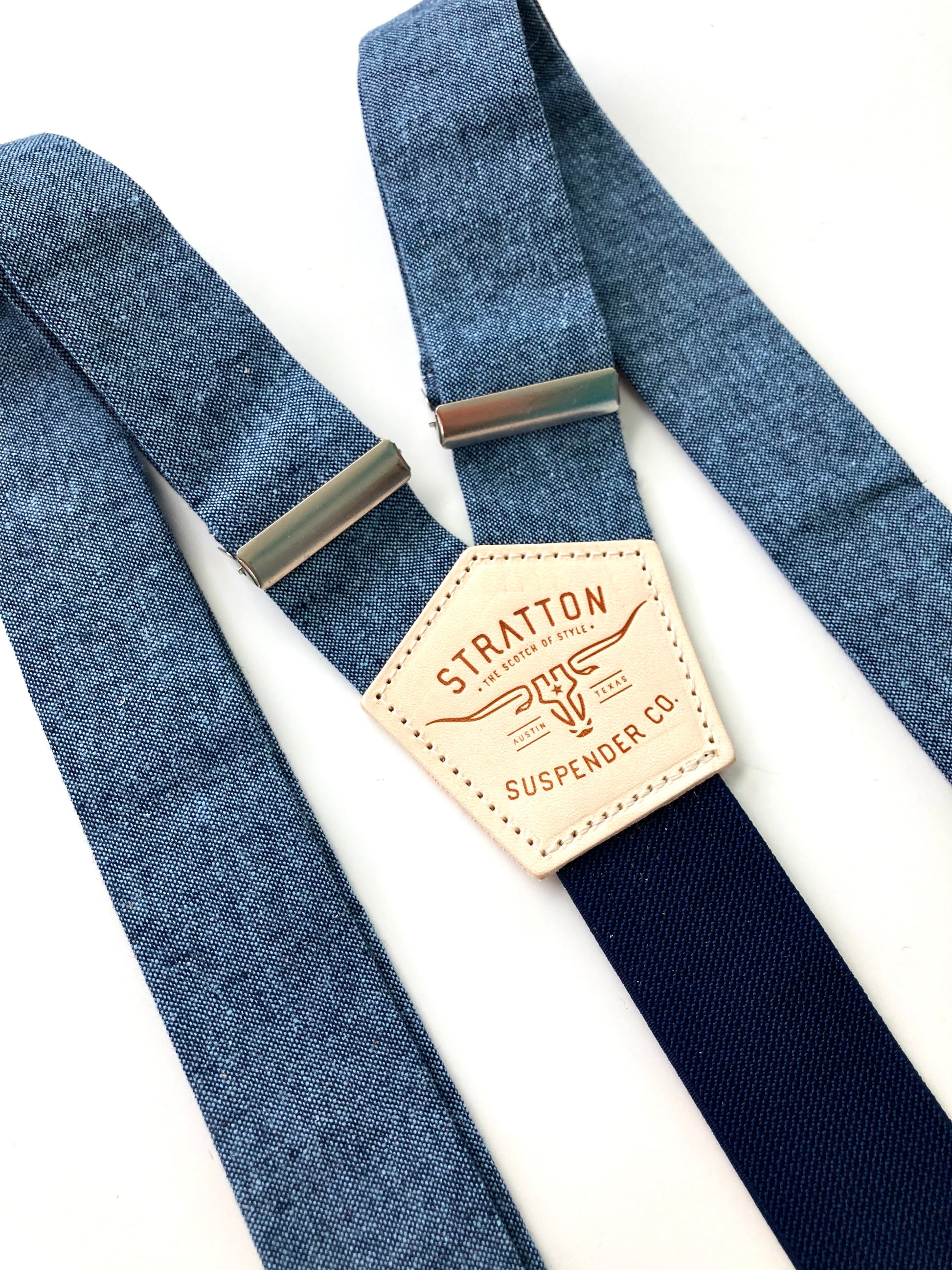 Close-up of Stratton Suspender Co. nautical blue linen suspenders with navy back strap and full-grain leather patch, ideal for rustic wedding or vintage menswear.