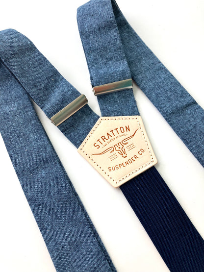 Close-up of Stratton Suspender Co. nautical blue linen suspenders with navy back strap and full-grain leather patch, ideal for rustic wedding or vintage menswear.