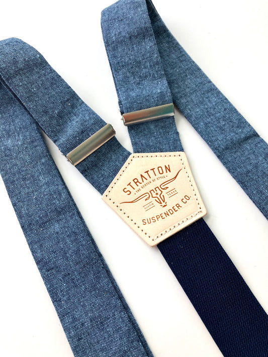 Close-up of Stratton Suspender Co. nautical blue linen suspenders with navy back strap and full-grain leather patch, ideal for rustic wedding or vintage menswear.