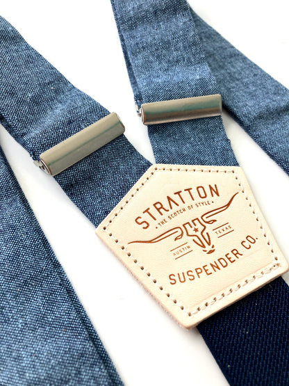 Close-up of Stratton Suspender Co. nautical blue linen suspenders with adjustable silver hardware and signature leather patch, ideal for rustic weddings or vintage groomswear.