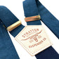 Elegant navy suspenders with deep blue elastic back strap and polished gold hardware, designed for refined wedding or event styling.