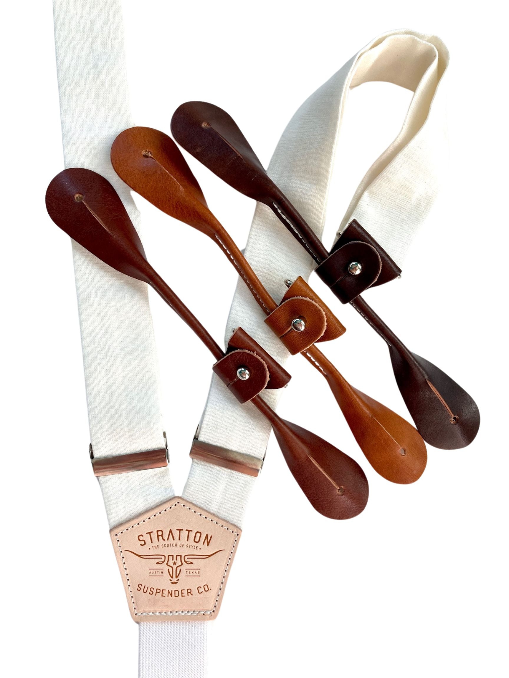 Pearl white linen suspenders by Stratton Suspender Co. with button-on ends in chocolate, cognac, and tan leather, styled for groomsmen or formalwear.