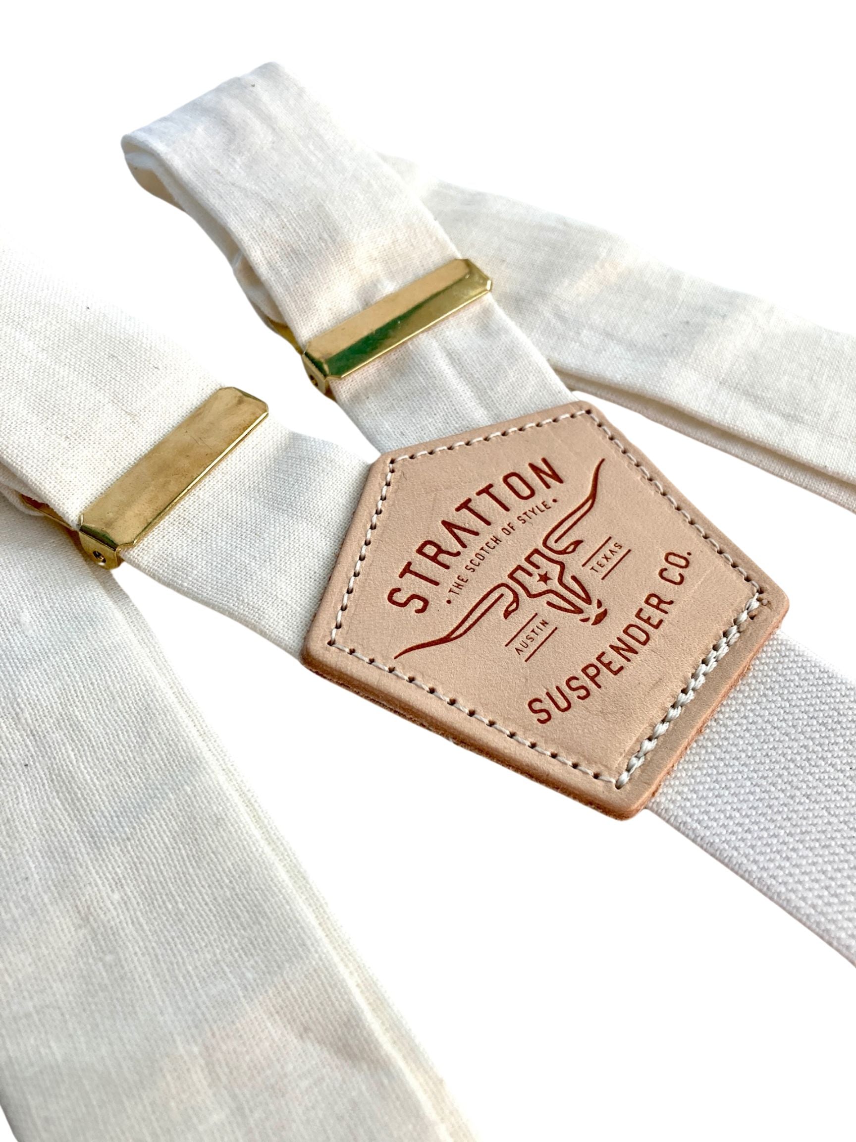 Close-up of pearl white linen suspenders with gold hardware adjusters and tan leather back patch by Stratton Suspender Co., ideal for weddings and formal events.