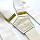 Pearl white linen suspenders with polished gold hardware, handmade for weddings, groomsmen, and classic menswear. Premium button-on braces in a timeless formal style.