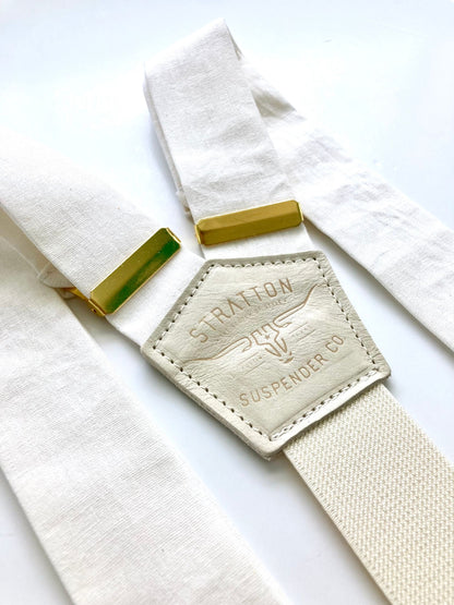 Pearl white linen suspenders with polished gold hardware, handmade for weddings, groomsmen, and classic menswear. Premium button-on braces in a timeless formal style.