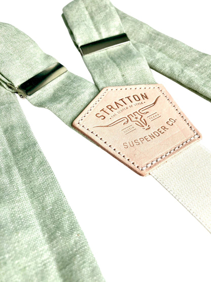 Close-up of pistachio green linen suspenders with natural leather back patch and silver hardware. Handmade in Texas, ideal for rustic weddings, groomsmen, and spring and summer formalwear.