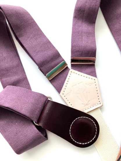 Plum linen women’s suspenders with wine leather magnetic clasps, close-up view of premium stitching and fabric.