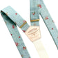 Full view of powder blue vintage floral linen suspenders with gold hardware and Stratton Suspender Co. leather patch, handmade in Texas for weddings and groomsmen.