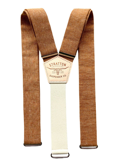 Flat lay of roasted pecan brown hand-woven linen suspenders with cream elastic back strap and Stratton Suspender Co. patch, designed for rustic wedding menswear, groomsmen gifts, or groom accessories.