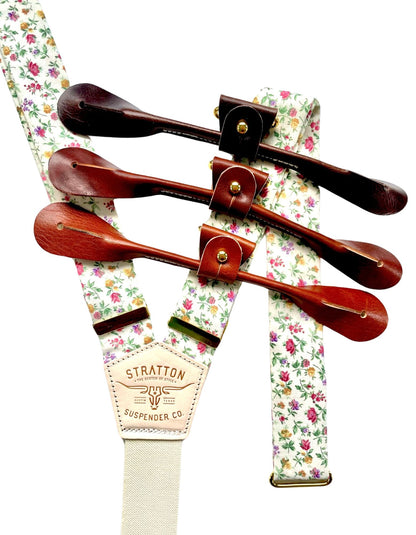 Close-up of rose garden floral linen suspenders with brown leather button-on straps, handmade in Texas by Stratton Suspender Co.—vintage wedding braces for groom and groomsmen, rustic formalwear accessory.