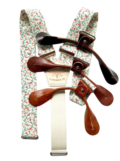 Full view of rustic orange and green floral suspenders with cream elastic back and brown leather button-on loops, handcrafted by Stratton Suspender Co. for rustic weddings and vintage formalwear.