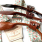 Close-up of rustic orange and green floral suspenders with brown leather button-on loops and cream elastic back, handmade by Stratton Suspender Co. for groomsmen and rustic wedding attire.