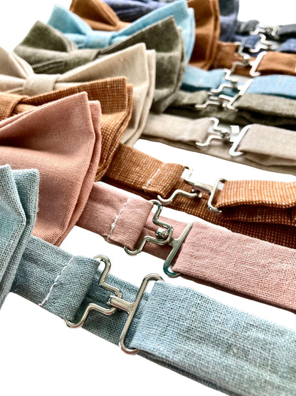 Close-up of silver polished brass clasps on handmade linen pre-tied bow ties in popular wedding colors, including powder blue, dusty rose, roasted pecan, and beige—ideal for groomsmen and formal wedding party attire.