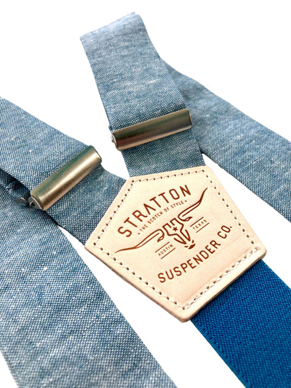 Sky blue linen suspenders with deep blue back strap and silver adjusters, featuring a tan leather patch embossed with Stratton Suspender Co. branding — ideal for groomsmen, vintage weddings, and formal menswear.