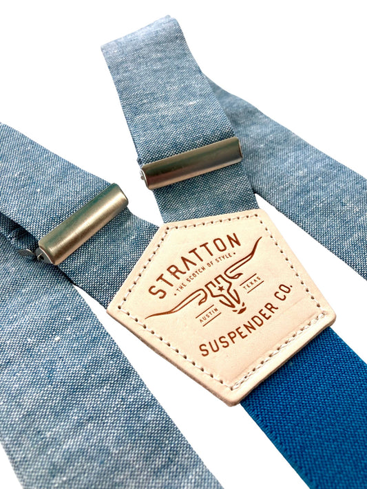 Sky blue linen suspenders with deep blue back strap and silver adjusters, featuring a tan leather patch embossed with Stratton Suspender Co. branding — ideal for groomsmen, vintage weddings, and formal menswear.
