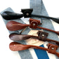 Sky blue linen suspenders with deep blue elastic back strap shown with full-grain leather attachment options in black, chocolate, cognac, and tan—handmade for weddings, groomsmen, and vintage menswear by Stratton Suspender Co.