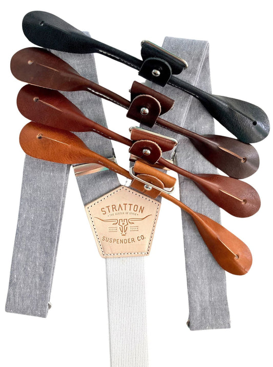 Steel gray linen button-on suspenders by Stratton Suspender Co., shown with tan, cognac, chocolate, and black full-grain leather button attachments. Rustic, American-made men's accessories handcrafted in Texas for weddings, workwear, or everyday vintage style.