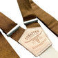 Close-up of handmade copper brown linen suspenders with cream elastic back strap, silver adjusters, and embossed leather patch. Made in Texas by Stratton Suspender Co., ideal for grooms, groomsmen, and rustic wedding style.