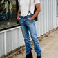 Man wearing gray linen button-on suspenders by Stratton Suspender Co. with jeans and boots. Perfect for rustic weddings, heritage workwear, and classic American menswear.