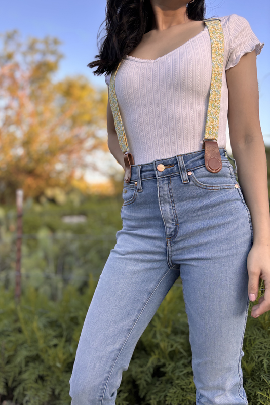 Women’s floral suspenders with leather magnetic clasp attachments, styled with denim for everyday wear.