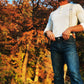Man wearing Tan Magnetic Clasp Suspenders with Beige Linen Straps, styled with a Henley shirt and denim against a vibrant autumn backdrop. A rugged, heritage-inspired look for modern menswear.
