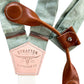 Tan leather magnetic clasp over pistachio green linen suspenders—perfect for groomsmen gifts and rustic wedding menswear.