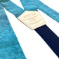 Close-up of turquoise blue Malibu linen wedding suspenders with a navy back strap and premium leather detailing. Handmade in USA – perfect for groomsmen, beach weddings, and vintage-inspired menswear.