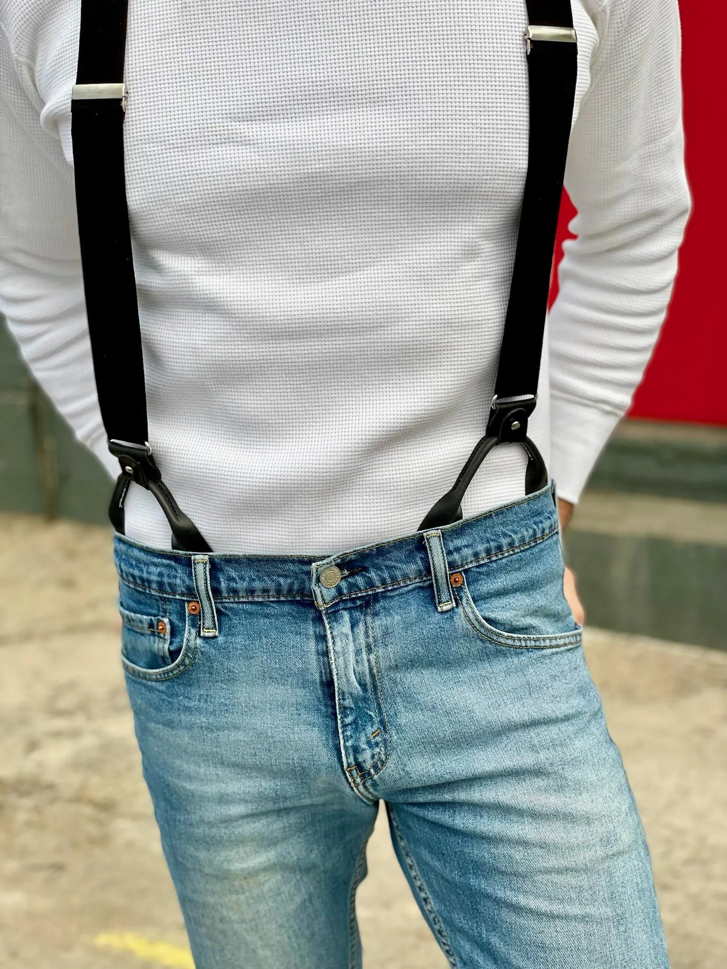 Tuxedo black linen button-on suspenders styled casually with light wash jeans and a white waffle-knit long sleeve shirt. Handmade in Texas by Stratton Suspender Co.