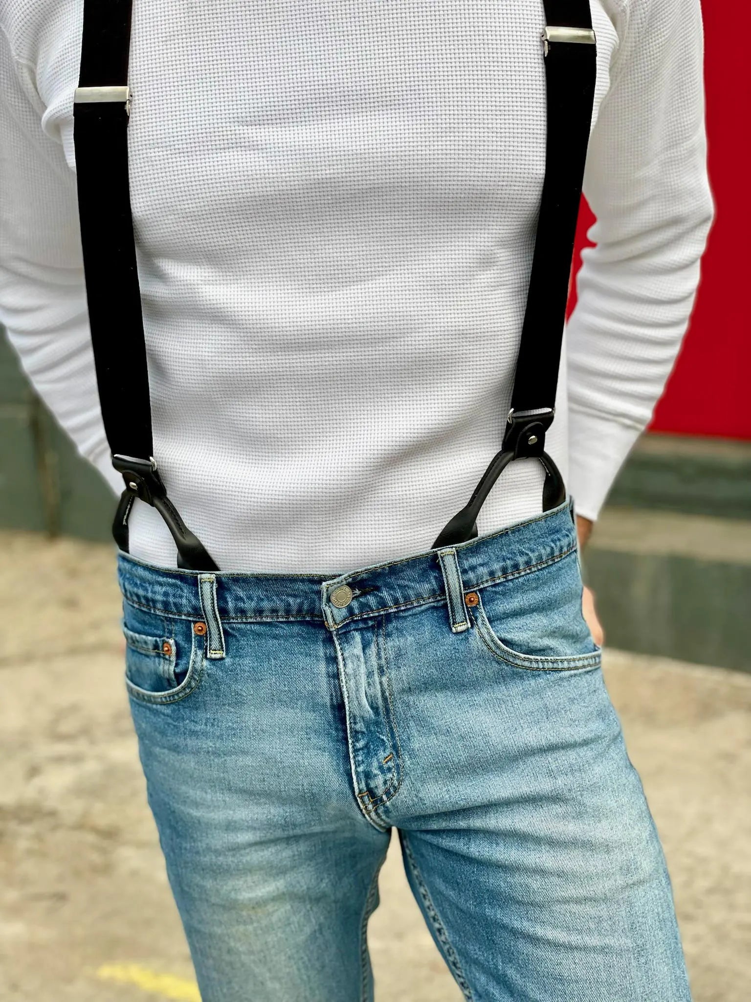 Tuxedo black linen button-on suspenders styled casually with light wash jeans and a white waffle-knit long sleeve shirt. Handmade in Texas by Stratton Suspender Co.