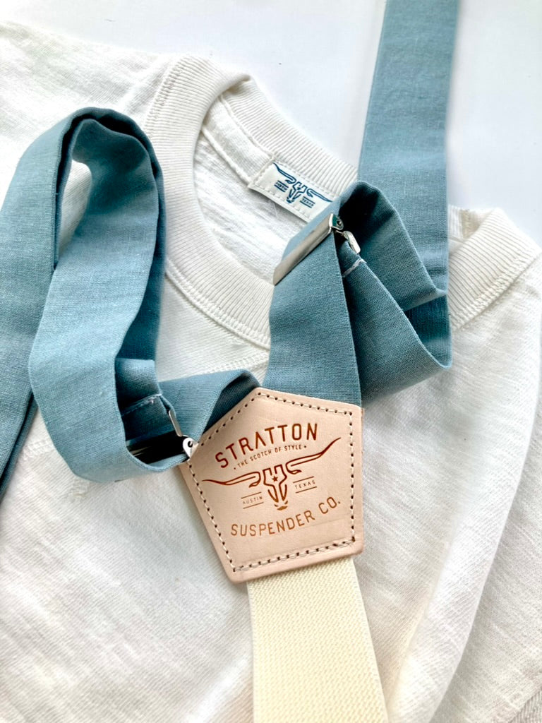 Vintage 1940s Heavyweight T-Shirt in White paired with Dusty Blue Suspenders by Stratton Suspender Co. Featuring a classic V-gusset neckline and ethically made in the USA, this rugged menswear set embodies timeless American workwear and heritage craftsmanship.