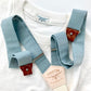 Vintage 1940s Heavyweight T-Shirt in White with Dusty Blue Suspenders by Stratton Suspender Co. A heritage-inspired workwear tee paired with ethically made button-on suspenders featuring genuine leather details and a natural cotton backstrap, embodying classic American menswear.