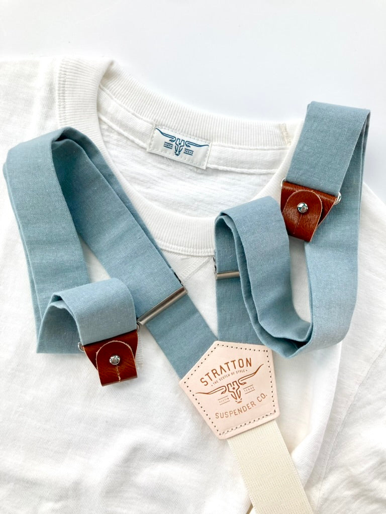 Vintage 1940s Heavyweight T-Shirt in White with Dusty Blue Suspenders by Stratton Suspender Co. A heritage-inspired workwear tee paired with ethically made button-on suspenders featuring genuine leather details and a natural cotton backstrap, embodying classic American menswear.